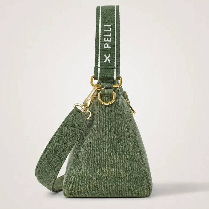 An olive green suede triangle shoulder bag with a matching green webbed strap featuring the white 'X PELLI' logo, displayed on a clean light gray background.